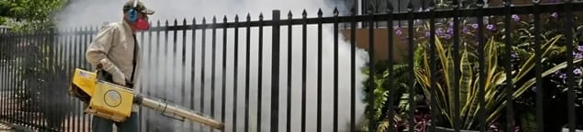 Mosquito control technician fogging a yard perimeter for mosquito reduction in Detroit, MI